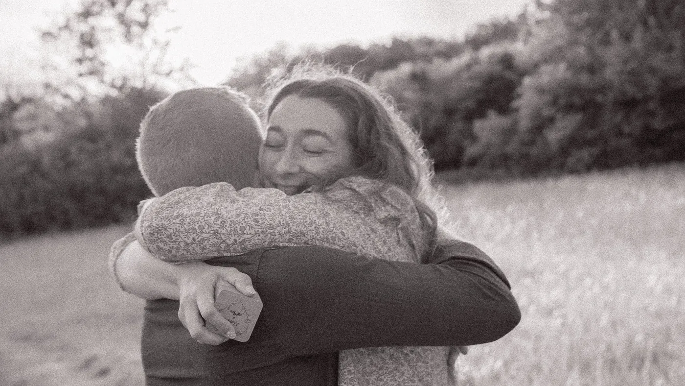 Surprise proposal photographer London black and white photo of the hug after she said yes